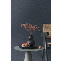 Nature morte décorative avec fleurs séchées dans un vase, une coupe de fruits et une chaise sur une table d''appoint devant un mur sombre