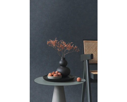 Nature morte décorative avec fleurs séchées dans un vase, une coupe de fruits et une chaise sur une table d''appoint devant un mur sombre