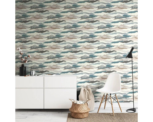 Espace de vie avec papier peint à motifs, commode, chaise et lampadaire pour une ambiance lumineuse et organisée.