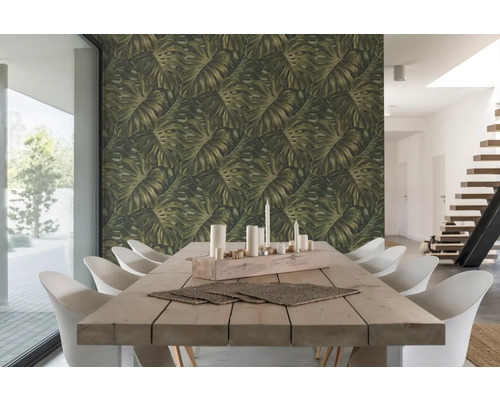 Salle à manger lumineuse avec table en bois, chaises blanches et papier peint à feuilles de Monstera