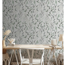 Pièce avec un papier peint à motifs de feuilles, un bureau et une décoration