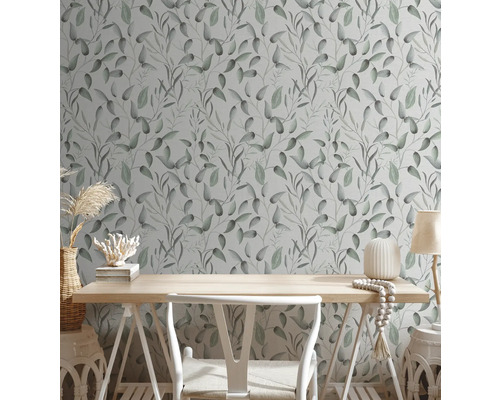 Pièce avec un papier peint à motifs de feuilles, un bureau et une décoration