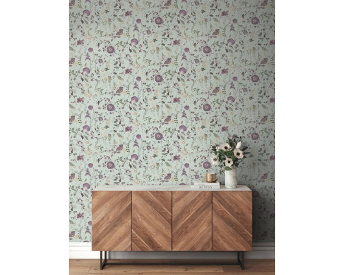 Wand mit Blumentapete und Holzkommode im Raum.