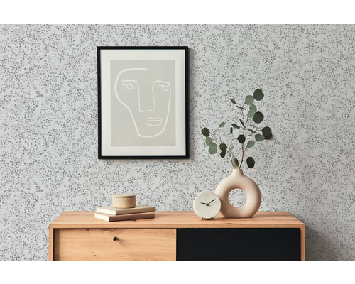 Vue d''une pièce avec papier peint à motifs, commode, tableau et décoration