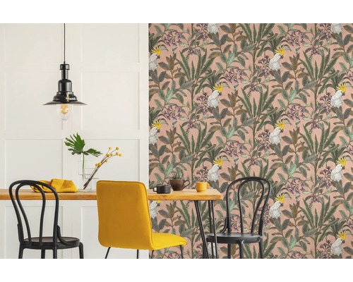 Salle à manger avec table à manger, chaises et papier peint avec des feuilles et des cacatoès.