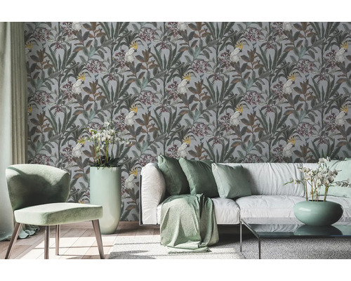 Intérieur avec papier peint à motifs de plantes et de cacatoès derrière un canapé