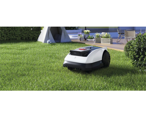 Robot tondeuse à gazon sur une pelouse devant une tente et une terrasse