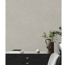 Nahaufnahme einer Wand mit einer beigen Textiltapete, die über einem Sideboard angebracht ist.