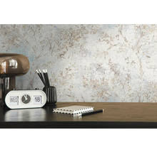 Szene mit Mustertapete, Tischleuchte, Kalender, Notizbuch, Stifthalter und Stiften auf einem Schreibtisch