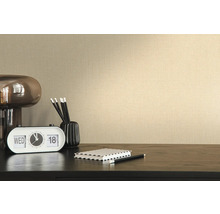 Nahaufnahme einer beigen Vliestapete mit Textilstruktur an einer Wand