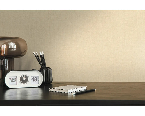 Nahaufnahme einer beigen Vliestapete mit Textilstruktur an einer Wand