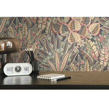 Detailansicht eines Zimmers mit einer floral gemusterten Tapete, einem Retro-Tischkalender, Stiften und einem Notizbuch