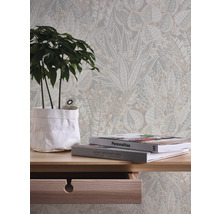 Dekoratives Interieur mit floraler Tapete, Zimmerpflanze und Büchern auf einem Holztisch.