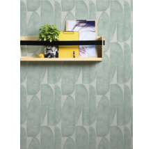 Wand mit Tapete im Blätterdesign und Regal mit Dekoration