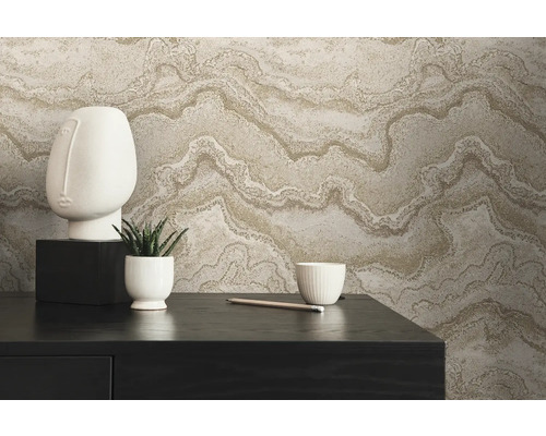 Dekoratives Arrangement mit Vliestapete in Marmoroptik, Skulptur, Pflanze und Schale auf einem Tisch