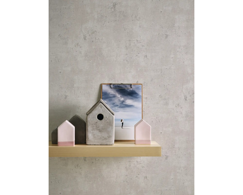 Dekorative Szene mit einer hölzernen Ablagefläche, auf der Dekorationen in Hausform und eine Bildklemme stehen.