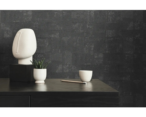 Gros plan d''une pièce avec une commode noire, un buste blanc, une plante, une tasse et une décoration de crayon devant un mur sombre