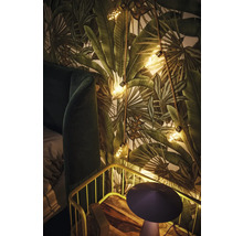 Dekoratives Schlafzimmer mit Pflanzenmustertapete, Lichterkette und Nachttisch.