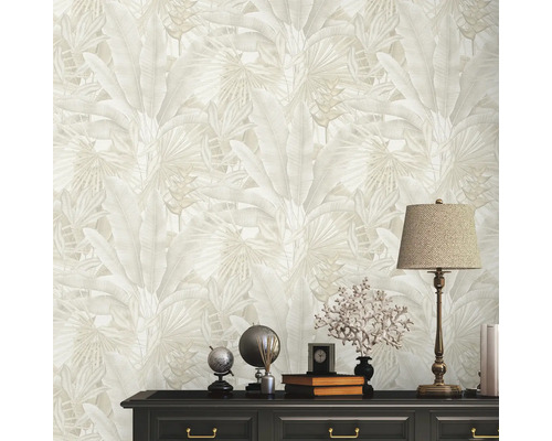 Nahaufnahme einer Wohnzimmerwand mit einer Tapete mit tropischem Blattmuster und einer Kommode