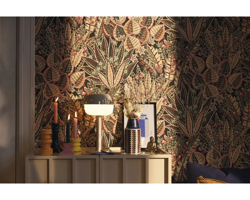 Dekoratives Zimmer mit floraler Tapete, Kommode und dekorativen Gegenständen.