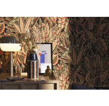 Dekoratives Zimmer mit gemusterter Tapete, Lampe, Vase mit Trockenblumen und Buddha-Figur