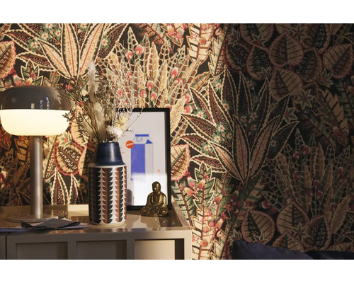 Dekoratives Zimmer mit gemusterter Tapete, Lampe, Vase mit Trockenblumen und Buddha-Figur