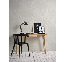 Ein Arbeitszimmer mit einem Schreibtisch, einem Stuhl und einer floralen Tapete.