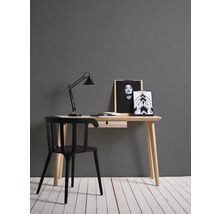 Schreibtisch mit Stuhl, Schreibtischlampe und dekorativen Bildern in einem Arbeitszimmer.