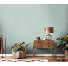 Wohnzimmer mit Holzboden, Kommode, Lampe, Pflanzen und Teppich