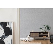 Wohnzimmer mit gemusterter Tapete, Holzschrank, Dekoration und Hund