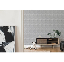 Wohnzimmer mit gemusterter Tapete, Holzkommode und liegendem Hund