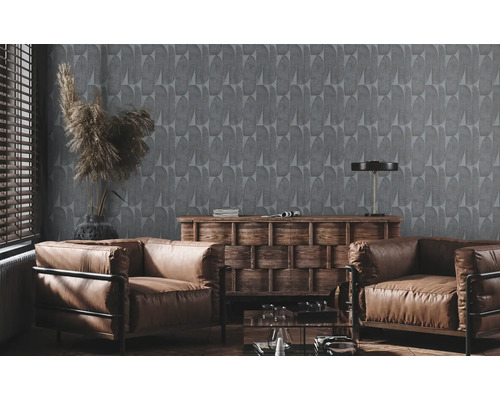 Wohnzimmer mit grauer Tapete, zwei braunen Ledersesseln und einer Holzkommode