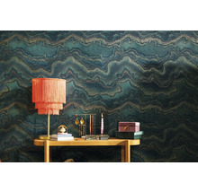 Szene mit gemusterter Tapete, Tisch und Dekorationsgegenständen wie Lampe, Schmuckständer und Kerze