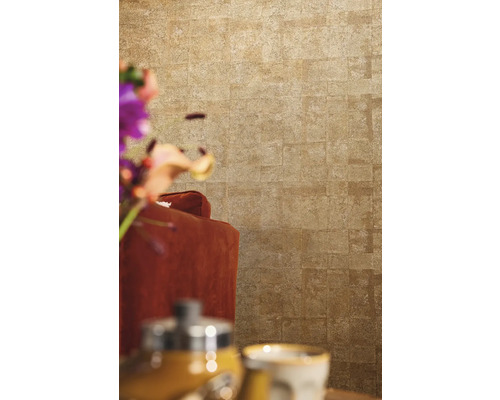 Gros plan d''un mur avec du papier peint aspect pierre derrière un fauteuil.