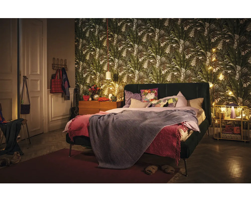 Schlafzimmer mit Bett, Nachttisch und gemusterter Tapete