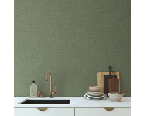 Küchenszene mit Spüle, Armatur, Geschirr und grüner Wand