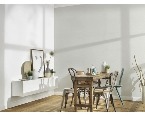 Helles Esszimmer mit Holztisch, Stühlen und weissem Wandregal mit Dekoration