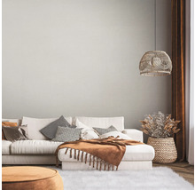 Wohnzimmer mit Sofa, Kissen, Decke, Lampe und Dekoration in einem hellen, gemütlichen Stil.