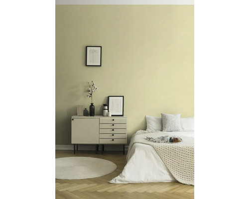 Schlafzimmer mit Bett, Kommode, rundem Teppich und Wanddekoration