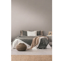 Schlafzimmer mit Bett, Pouf und dekorativer Wandtapete