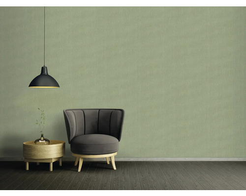 Wohnraum mit Sessel, Beistelltisch und Pendelleuchte vor einer Tapete