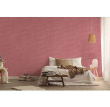 Helles Schlafzimmer mit Bett vor einer gemusterten Wandtapete