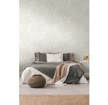 Schlafzimmer mit Bett, Pouf und Tapete mit Blattmuster