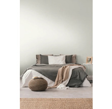 Schlafzimmer mit Bett, Nachttisch, Hocker und Teppich