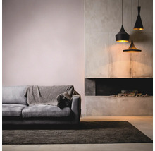 Wohnzimmer mit grauem Sofa, Teppich, Kamin und Hängelampen.