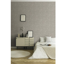 Schlafzimmer mit gemusterter Tapete, Kommode und Bett