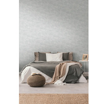 Schlafzimmer mit Bett, Nachttisch und hellgrauer Tapete