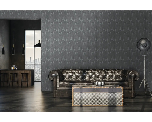 Innenansicht eines Wohnzimmers mit einer grauen gemusterten Tapete, einem Ledersofa und einer Stehlampe