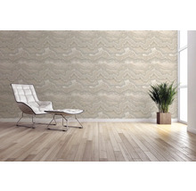 Heller Raum mit gemusterter Tapete, Sessel und Zimmerpflanze