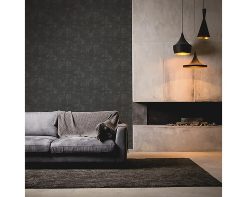 Salon avec canapé gris, couverture, papier peint foncé, cheminée et trois suspensions